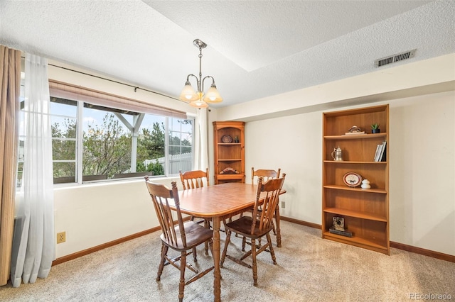 dining space with visible vents, baseboards, light colored carpet, a textured ceiling, and a chandelier