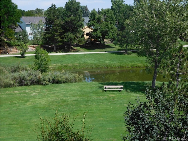 view of property's community with a lawn and a water view