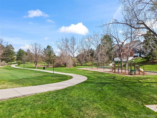 view of property's community with a lawn and playground community