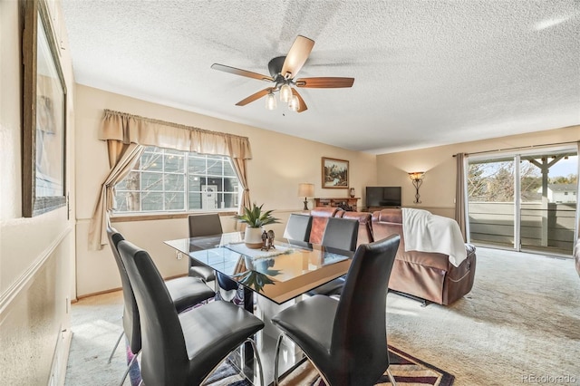 carpeted dining area featuring a ceiling fan and a textured ceiling