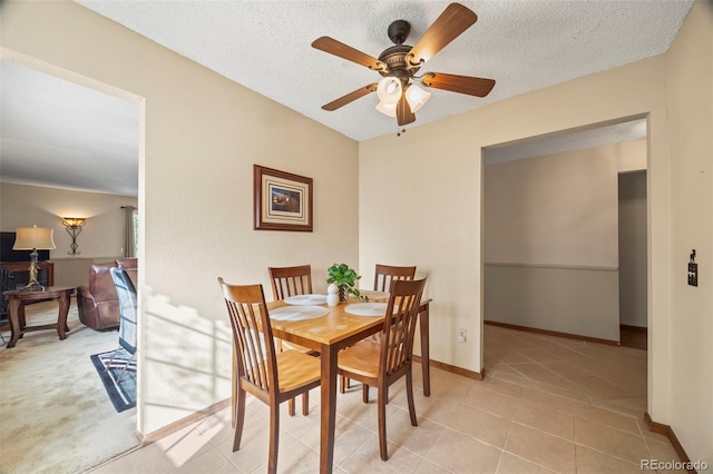 dining room with baseboards, a textured ceiling, ceiling fan, and light tile patterned floors