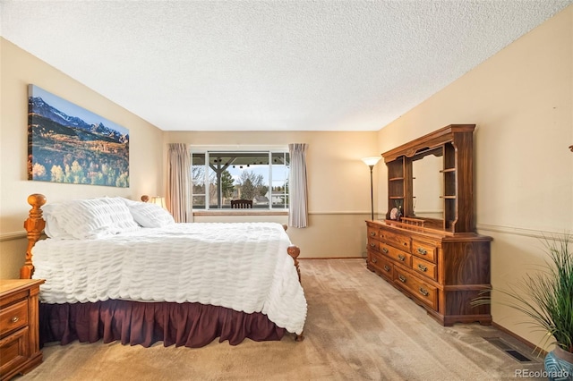 bedroom with baseboards, visible vents, a textured ceiling, and light colored carpet