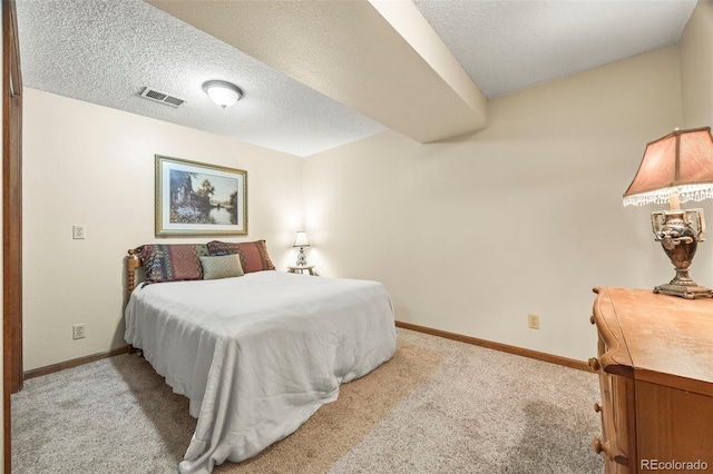carpeted bedroom featuring baseboards, a textured ceiling, and visible vents