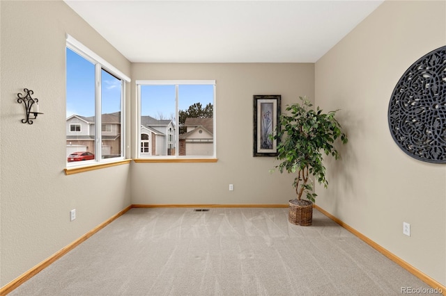 unfurnished room featuring carpet and baseboards