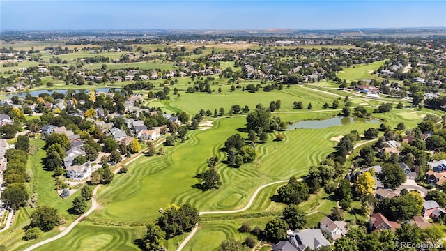 drone / aerial view with golf course view and a water view