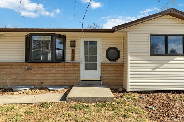 view of exterior entry with brick siding