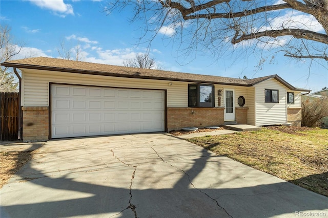 ranch-style home featuring brick siding, an attached garage, concrete driveway, and fence