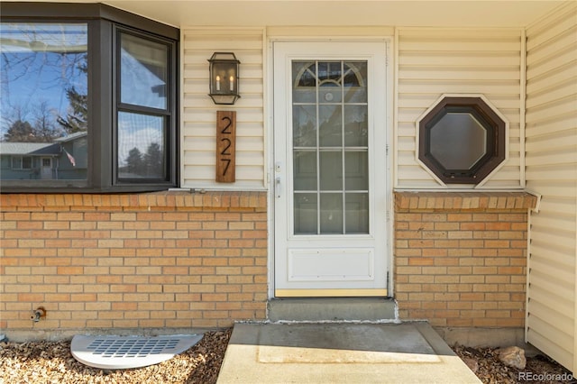 entrance to property featuring brick siding