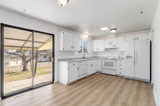 kitchen with visible vents, under cabinet range hood, a sink, white appliances, and light countertops