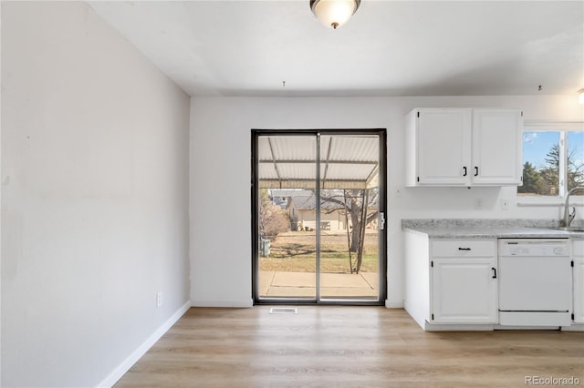 unfurnished dining area featuring baseboards, light wood finished floors, and a sink