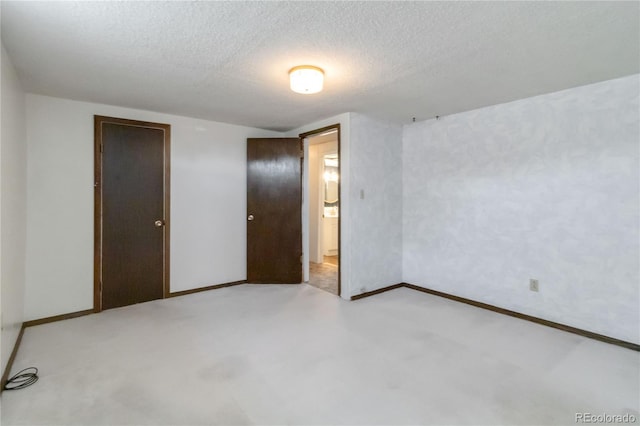 unfurnished bedroom featuring baseboards, a textured ceiling, and carpet