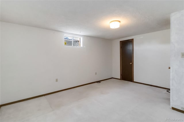 spare room with baseboards and light carpet