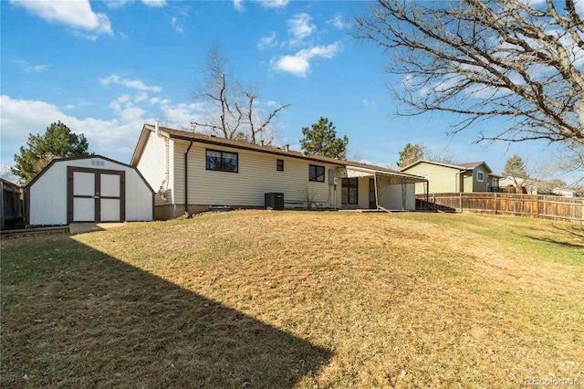 back of house with an outbuilding, fence, a yard, central AC, and a storage shed