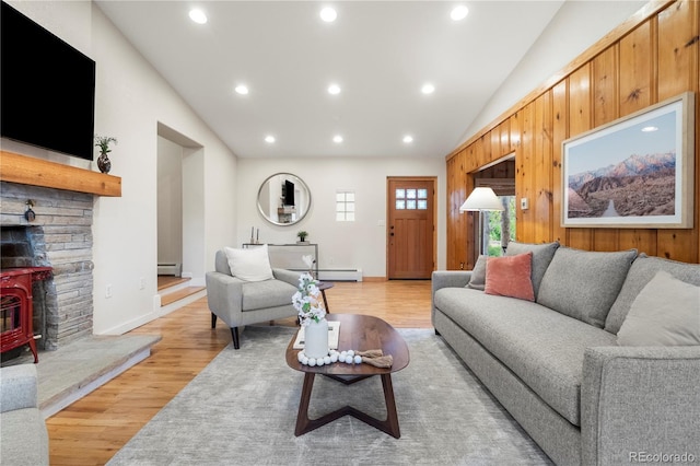 2020 Routt St, Lakewood, CO 80215 - living room with vaulted ceiling, a baseboard radiator, light wood-type flooring, recessed lighting, and a wood stove