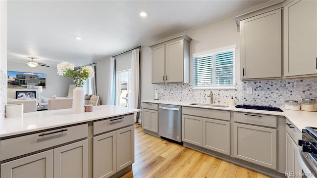 kitchen with gray cabinets, a sink, stainless steel appliances, decorative backsplash, and recessed lighting
