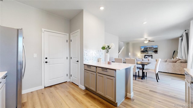 kitchen with freestanding refrigerator, a ceiling fan, gray cabinetry, and light wood-type flooring