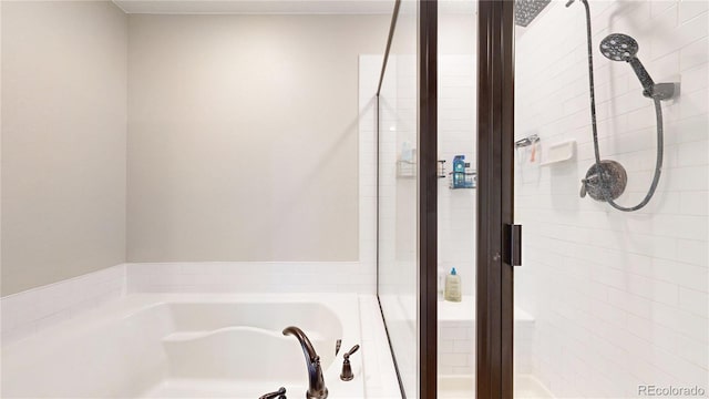 bathroom with a stall shower and a bath