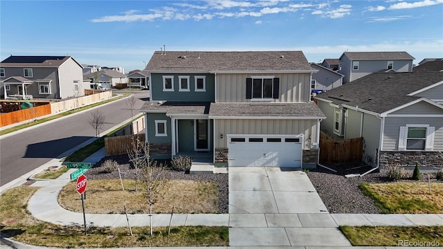 traditional-style home featuring board and batten siding, a residential view, fence, concrete driveway, and a garage