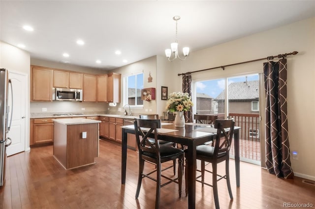 kitchen featuring appliances with stainless steel finishes, wood-type flooring, plenty of natural light, a kitchen island, and recessed lighting