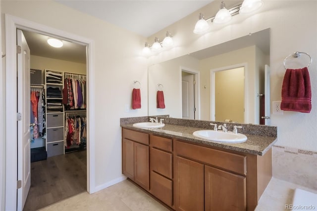 full bath with double vanity and a walk in closet