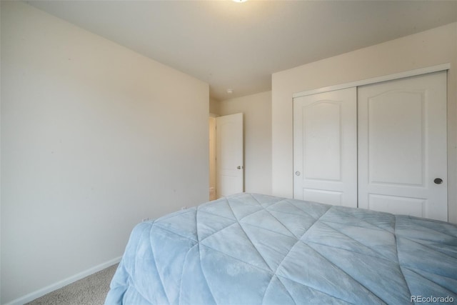 bedroom with carpet, baseboards, and a closet