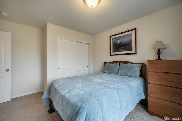 carpeted bedroom with a closet and baseboards