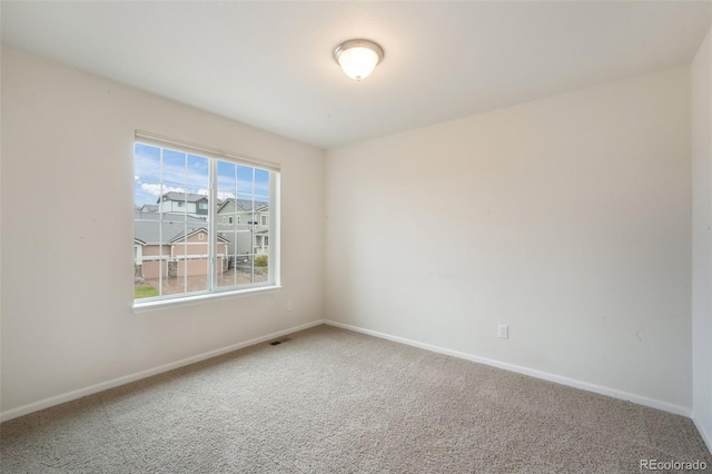 carpeted spare room featuring baseboards