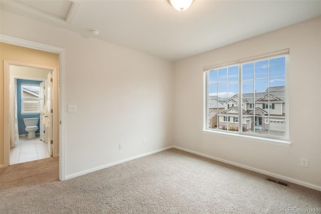 unfurnished room with carpet, baseboards, and attic access