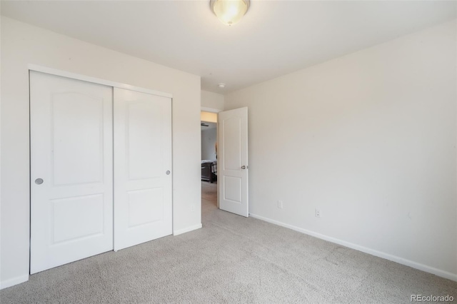unfurnished bedroom featuring carpet flooring, a closet, and baseboards