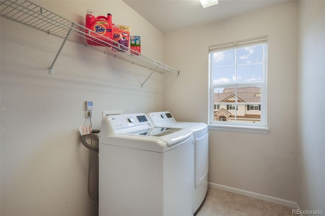 laundry room with washer and clothes dryer, baseboards, and light tile patterned floors