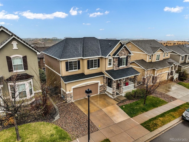 craftsman inspired home featuring stone siding, a garage, driveway, stucco siding, and a residential view