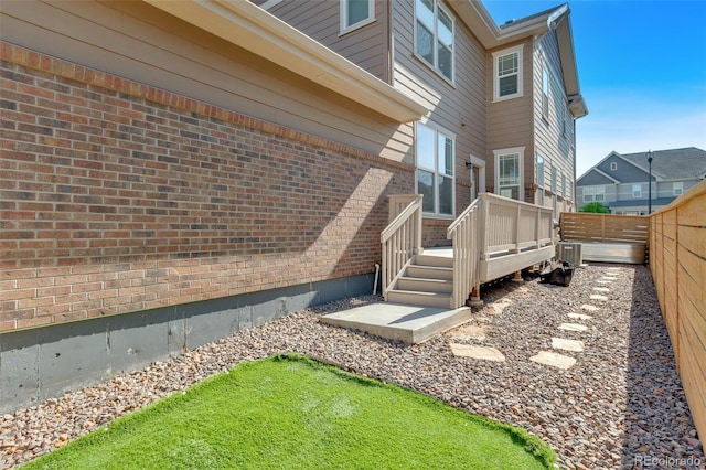 315 Zeppelin Way, Fort Collins, CO 80524 - view of side of property featuring a wooden deck, a fenced backyard, brick siding, and central air condition unit