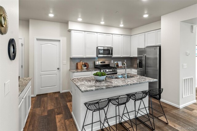 315 Zeppelin Way, Fort Collins, CO 80524 - kitchen with stainless steel appliances, a sink, dark wood-type flooring, white cabinetry, and a breakfast bar area