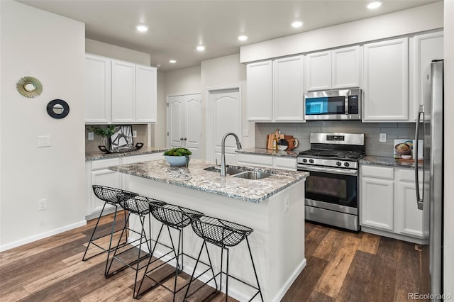 315 Zeppelin Way, Fort Collins, CO 80524 - kitchen featuring stainless steel appliances, a sink, decorative backsplash, dark wood-style flooring, and white cabinets