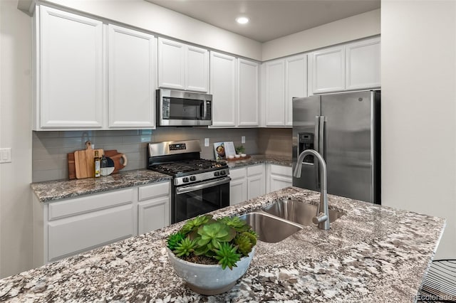 315 Zeppelin Way, Fort Collins, CO 80524 - kitchen with appliances with stainless steel finishes, a sink, white cabinets, recessed lighting, and backsplash