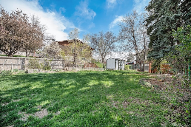 view of yard featuring a storage shed, an outbuilding, and a fenced backyard