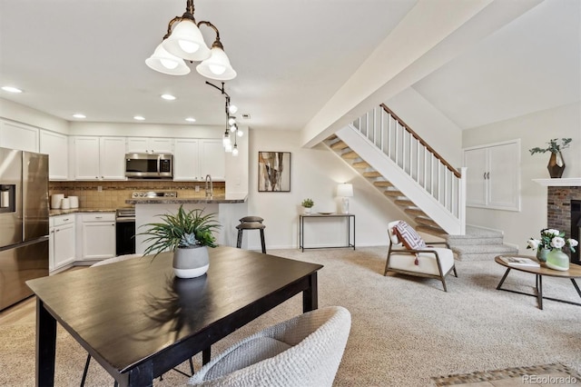 dining area featuring stairway, recessed lighting, baseboards, a brick fireplace, and light carpet