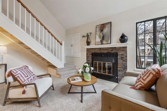 living room featuring a brick fireplace, a healthy amount of sunlight, and stairs