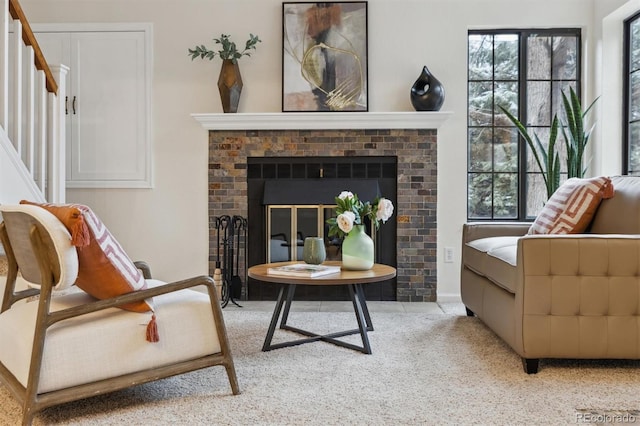 sitting room with carpet floors, a fireplace, and stairway