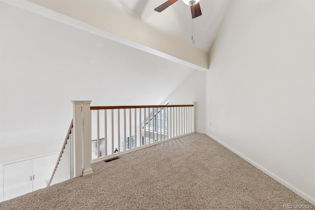 interior space with carpet flooring, lofted ceiling, baseboards, visible vents, and ceiling fan