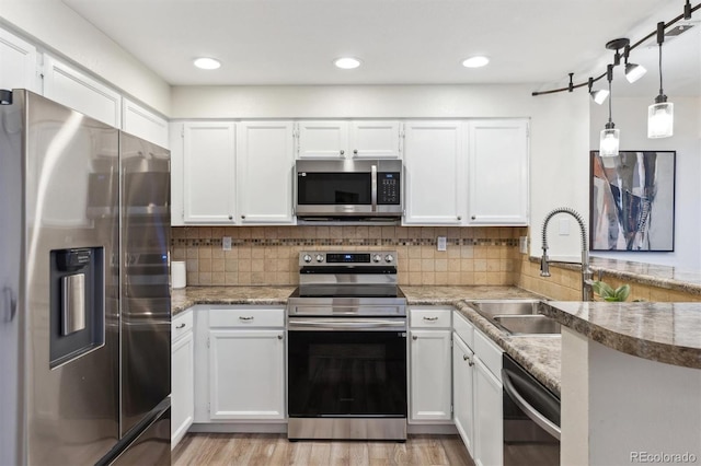 kitchen featuring decorative backsplash, white cabinetry, a sink, and stainless steel appliances