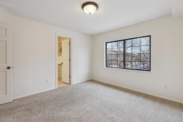 carpeted spare room featuring baseboards