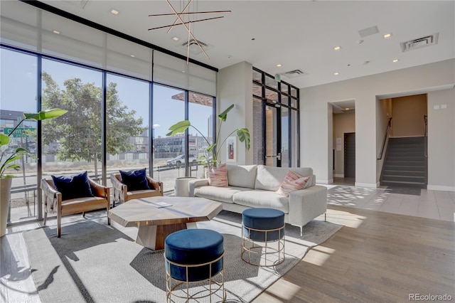 living area with visible vents, stairway, baseboards, and wood finished floors