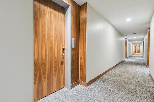 hallway featuring carpet, visible vents, and baseboards