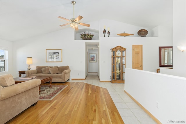 tiled living room with high vaulted ceiling and ceiling fan