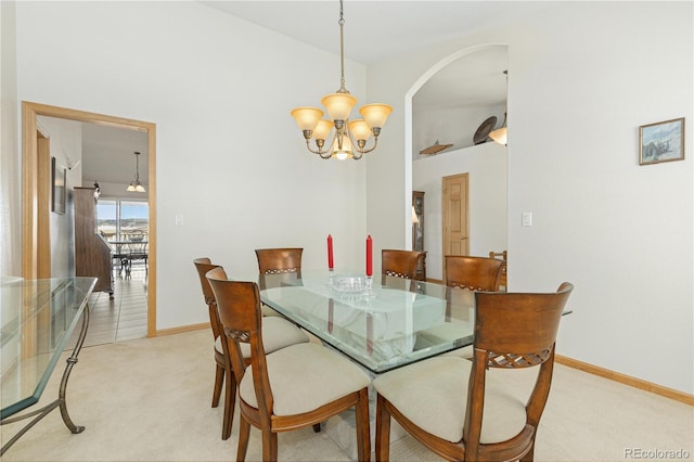 carpeted dining area featuring a notable chandelier