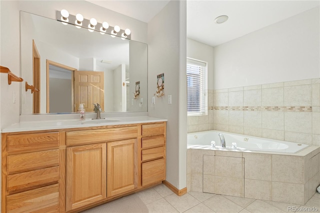 bathroom with a relaxing tiled tub, vanity, and tile patterned floors