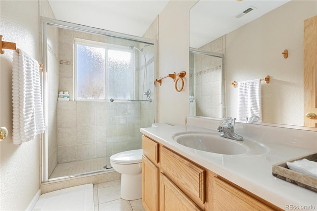 bathroom featuring toilet, a shower with shower door, tile patterned floors, and vanity