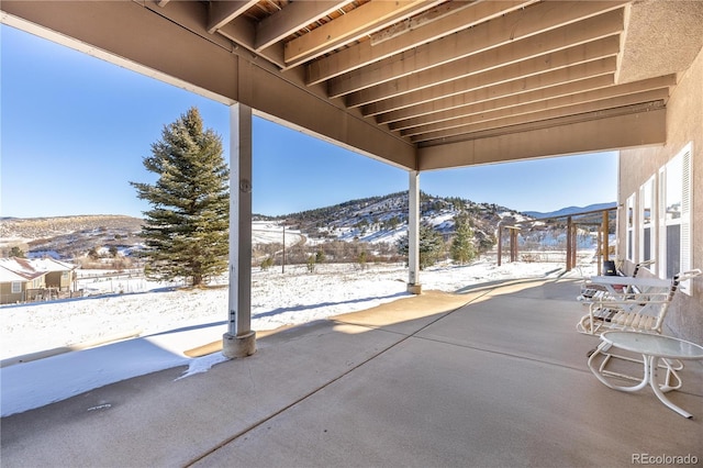 snow covered patio with a mountain view