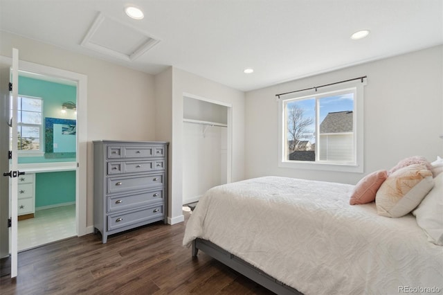 bedroom with dark wood-type flooring, a closet, recessed lighting, attic access, and baseboards